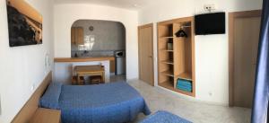 埃斯卡纳Apartamentos Playa Sol的小房间设有蓝色的床和厨房
