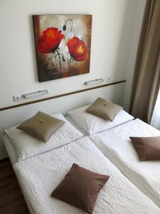 维也纳KIBI Rooms self check-in的一张带两个枕头的床和墙上的绘画