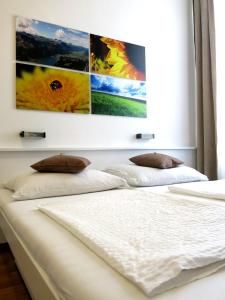 维也纳KIBI Rooms self check-in的卧室配有两张白色床,墙上挂有绘画作品