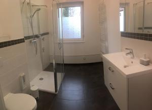 武尔岑zentral gelegene top ausgestattete Wohnung的带淋浴、卫生间和盥洗盆的浴室