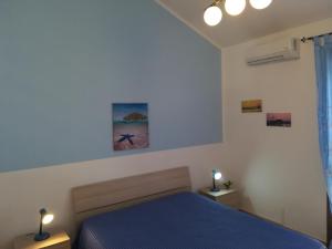 圣维托罗卡波RESIDENCE 3 STARs SAN VITO LO CAPO的一间卧室配有一张蓝色的床和两盏灯。