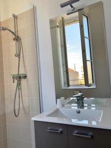 沙特拉永普拉日Le Rayon de Soleil的浴室配有盥洗盆和带镜子的淋浴
