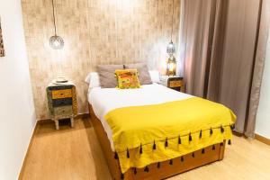 塞维利亚Triana Luxury Home的一间卧室配有一张黄色毯子床