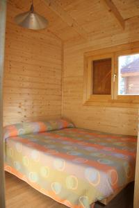 PanzanoCamping Cañones de Guara y Formiga的小木屋内的一张床位,设有窗户