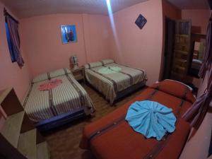 帕纳哈切尔Hotel Encuentro del Viajero的一间小房间,配有两张床,一间房间,