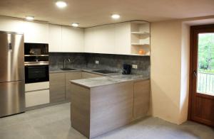 ArráyozCasa Artxea的厨房配有白色橱柜和不锈钢冰箱