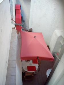 布杰鲁AL MARE, AL SOLE, SI', ma nella CASA DEL MINATORE的一间设有红色桌子和红色遮阳伞的房间