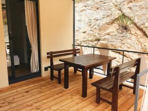 斯克拉丁Illyria Apartments的阳台上设有一张木桌和两个长椅
