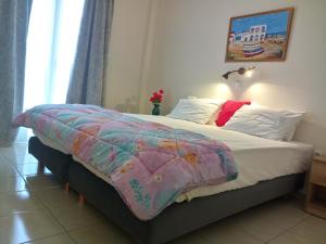 帕罗奇亚梅莱蒂斯公寓酒店的一间卧室配有一张带彩色毯子的床