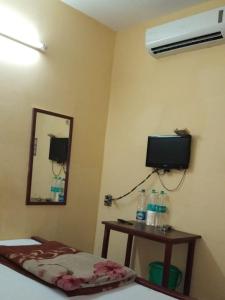 加尔各答Narendra niketan的客房设有床、镜子和电视。