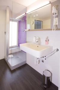 巴塞尔雷斯利莱蒂餐厅酒店的浴室配有白色水槽和淋浴。