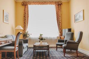 巴特瑙海姆斯浦特尔酒店的客厅配有椅子、桌子和窗户
