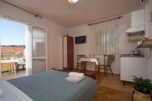 尼亚卢卡Studios Bačić的一间卧室配有一张床,厨房配有桌子
