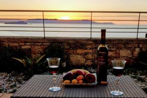 干尼亚Sody Magnificent Bay View的一张桌子,上面放着两杯葡萄酒和一碗水果