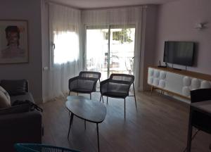 托里代巴拉A3A Baixa Mar的客厅配有椅子、桌子和电视