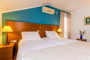 米利尼Pansion Srebreno的一间卧室配有一张白色大床和蓝色的墙壁