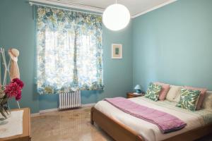 阿斯蒂La Casa di Giò的一间拥有蓝色墙壁的卧室、一张床和窗户