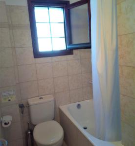 桑加拉达Giordani Guesthouse的一间带卫生间和浴缸的浴室以及窗户。