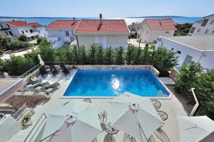 曼德雷Deluxe Villa No.10 - Rooms & Apartments的庭院内带遮阳伞的游泳池