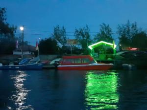 克里尚Camping Casuta Mihaela的夜间水中一艘红色的船