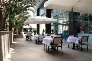 荷兹利亚本杰明商务酒店的一间带桌椅和遮阳伞的餐厅