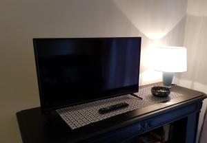 卡萨莱蒙费拉托L'airone apartment的一张桌子上的平板电视,配有台灯