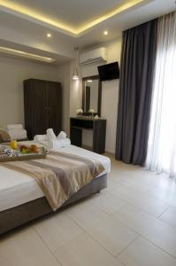 卡尼奥提Aparthotel Pagidas的酒店客房设有一张大床和一台电视。