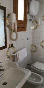 庞贝Villaggio "Camping Pompei"的一间带卫生间、水槽和镜子的浴室