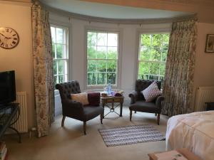 贝尔福德Buckton Farmhouse的一间卧室配有两把椅子和一张桌子,窗户