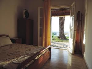 圣斯特凡诺斯APARTMENTS PELI-MARIA的一间卧室设有一张床,并有通往庭院的门