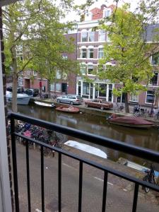 阿姆斯特丹Jordaan Canal View Apartment的享有河流美景,设有船只