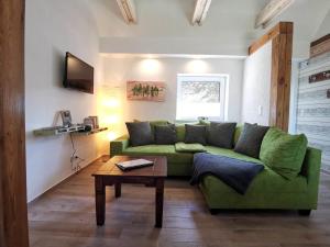 BanneminDoppelhaushälfte Nordwind vom Naturhof Usedom的客厅配有绿色沙发和桌子