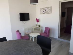 沙特拉永普拉日Appartement Aix (1 à 2 personnes)的一间用餐室,配有紫色椅子和一张桌子