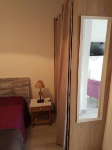 沙特拉永普拉日Appartement Aix (1 à 2 personnes)的一间带镜子、一张床和一张桌子的卧室
