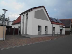 PouchFerienapartment-Monteurwohnung-Muldestausee的街上有红色屋顶的白色房子