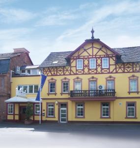 赫斯巴赫戈贝酒店的黄色建筑,有 ⁇ 形屋顶