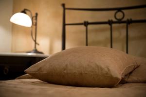 雅典大理石屋酒店的枕头坐在床头灯旁