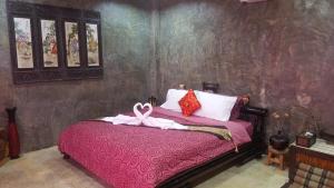 Rong SakAngels Chambres d'hotes的一间卧室配有粉红色的床和粉红色的带子
