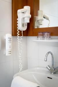 莱顿新密涅瓦莱顿城市酒店的浴室设有白色水槽和镜子