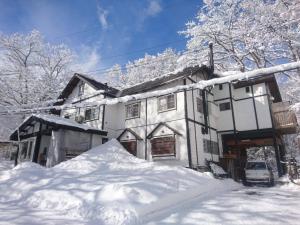 白马村Hakuba Matata Lodge的前面有一堆积雪的房子