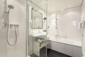 祖尔斯Hotel Enzian的带淋浴、盥洗盆和浴缸的浴室