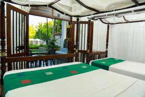 坦加拉Goyambokka Guesthouse的带阳台的客房内的两张床