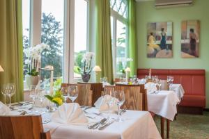 巴特罗森菲尔德诺尔特曼-彼得斯酒店的用餐室配有带白色桌布的桌子