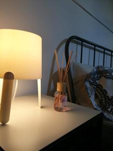 兰恰诺B&B Piccolo Loft del Borgo的一张桌子,上面有台灯和一瓶瓶子,上面有植物