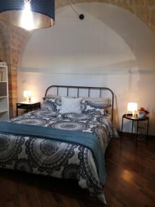 兰恰诺B&B Piccolo Loft del Borgo的一间卧室配有一张床和两张带台灯的桌子。