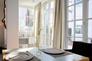 宾茨Atelier-Appartement Ambienta im Zentrum von Binz的客厅配有桌子和一些窗户