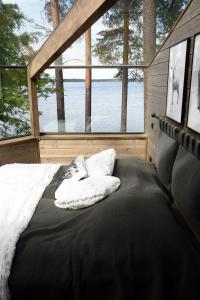 HankasalmiRevontuli Resort Glass Igloos的水景小屋内的一张床位