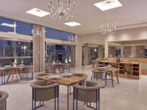 卡拉马孔Golden Sun Resort - Adults Only的用餐室配有桌椅和吊灯。