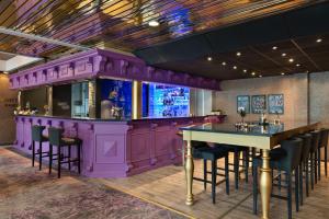 约维克约维克克拉丽奥连锁酒店的餐厅内的紫色酒吧,配有桌椅