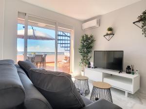 卡萨雷斯2268-Penthouse with terrace seaview的客厅配有灰色的沙发和电视